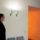 Luceplan Wandlampe Lola Lichtwirkung drehbar an einer Wand in einem Raum mit warmem Licht.