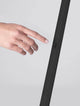 Hand, die die Lusa LED Stehlampe 3000K Champagner, Schwarz berührt, um das Licht zu steuern.