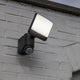 Lutec Sunshine LED-Außenwandleuchte IP44 500lm Schwarz an einer weißen Wand mit Bewegungsmelder angeordnet.