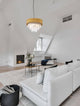 Magnolia Pendelleuchte Zylindrisch 6-flammig Ø 50cm Gold im modernen Wohnzimmer mit weißem Sofa