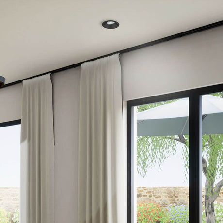 Brandon luminaire encastré rond dans un espace moderne avec des rideaux et de grandes fenêtres.