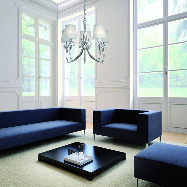 Loewe 5-flammige Pendellampe breit in modernem Wohnzimmer mit blauen Sofas und großen Fenstern.