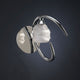 Loop Wandlampe mit geschwungener Form und eleganter Lichtwirkung in Silber und Glas.