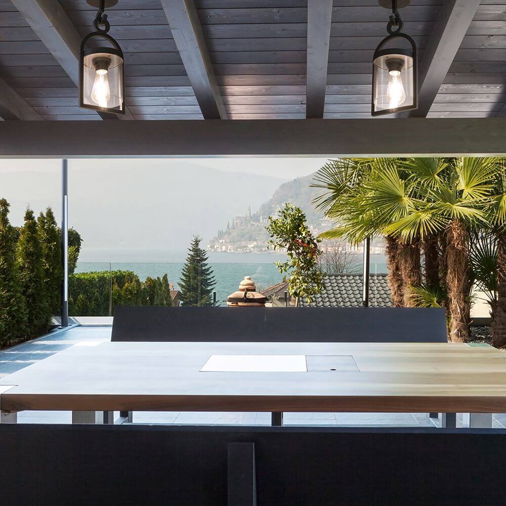 Maya Außen-Deckenleuchte Dunkelgrau in modernem Außenbereich mit Blick aufs Wasser und Palmen.