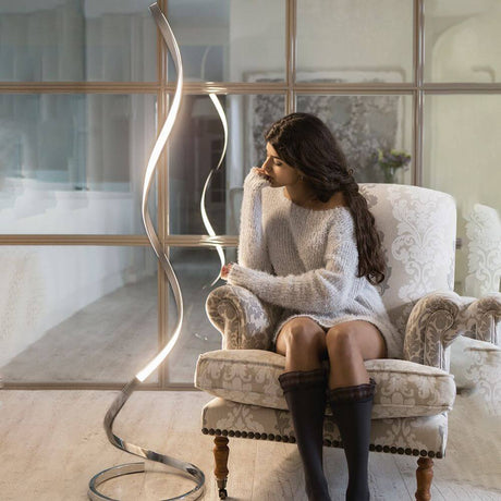 Nur Spirale LED-Stehleuchte Dimmbar Klein neben Sessel in modernem Wohnzimmer, geschwungene Metallform und warmweißes Licht