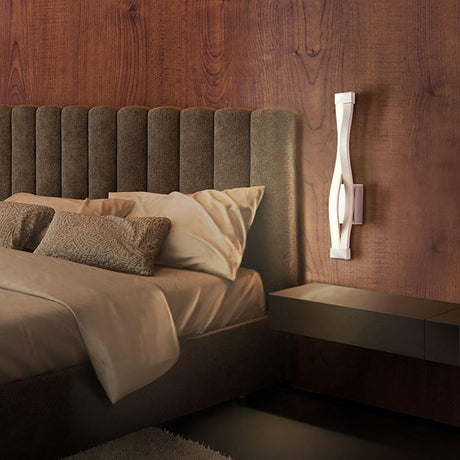 Sahara LED wall light above a modern-designed bed with pillows and nightstand.