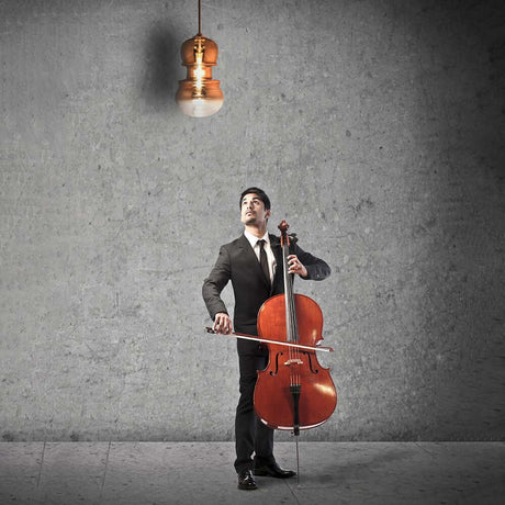 Sonata violin pendant light above a cellist in elegant suit attire, looking at the light.