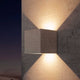 Taos Außen-LED-Wandleuchte Beton in quadratischer Form an grauer Wand, strahlendes Lichtschema.