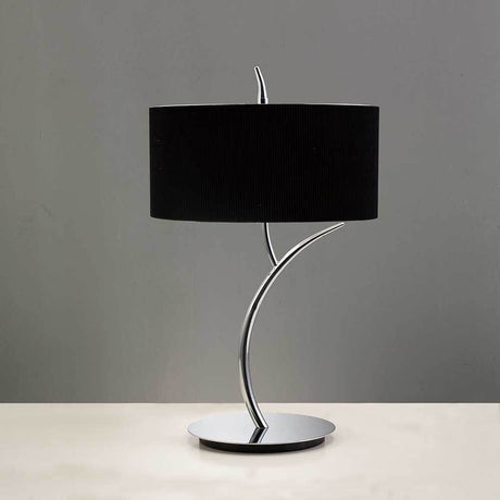 Tischlampe Eve in modernem Design mit schwarzem Textilschirm und Metallfuß auf einem Tisch.
