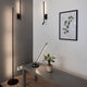 Moderne Torch LED-Stehleuchte in minimalistischem Raum mit Pflanzen und Wandbildern.