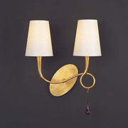 Wandleuchte 80W Paola mit zwei Schirmen und goldfarbenem Design auf dunklem Hintergrund.