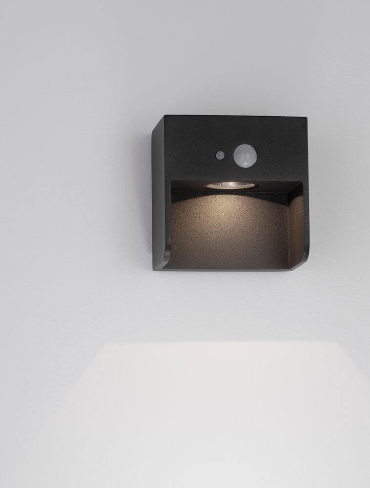 Marta LED Außenwandleuchte 3000K Anthrazit IP65 an einer Wand montiert, modernes Design mit Sensor.
