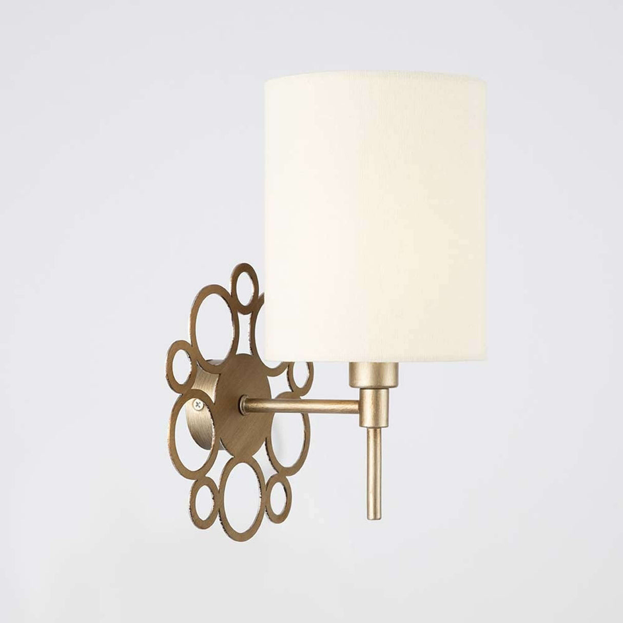 Anna Wandleuchte Antik-Gold mit cremefarbenem Stoffbezug und metallischem Rahmen in Antik-Gold.