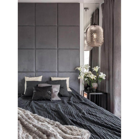 Dunas Pendelleuchte Small über einem modernen Bett mit grauen Wänden und stilvollen Kissen.