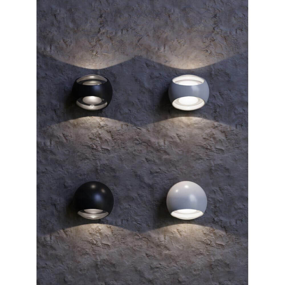 Stream LED Außen-Wandleuchte IP54 in Schwarz und Weiß an einer Wand installiert.
