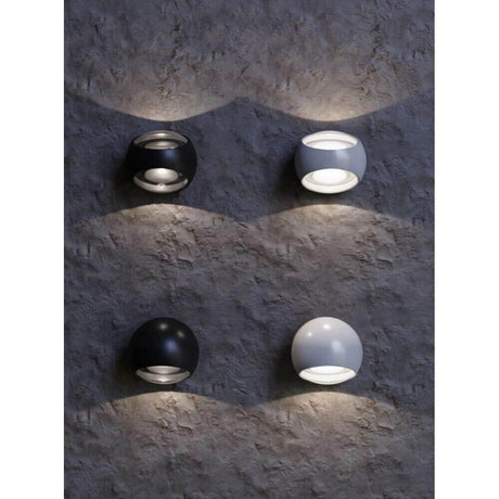 Stream LED Außen-Wandleuchte IP54 in Schwarz und Weiß an einer Wand installiert.