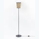 Metall Stehleuchte mit Heuschirm, elegante Stehlampe aus Heu und schwarzem Metall, natürliche Wohnatmosphäre.