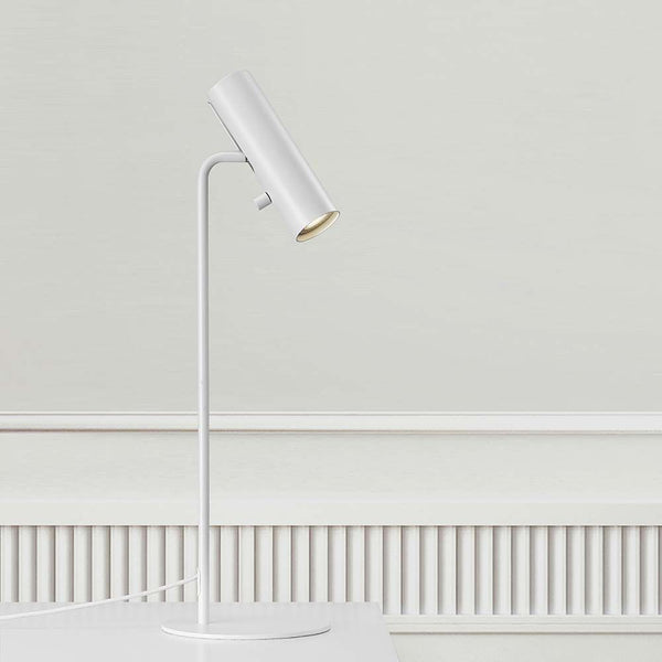 Lámpara de mesa Mib 6 blanca en diseño escandinavo con cabeza de lámpara ajustable sobre una mesa.