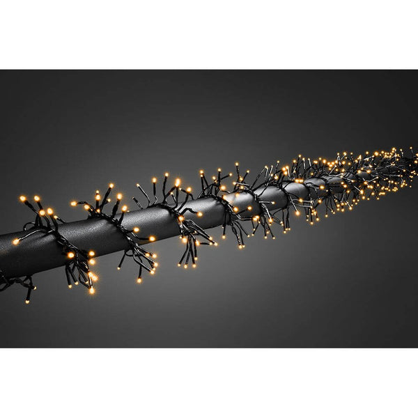 9m Micro LED cluster fairy lights with 8 functions, 960 amber diodes IP44 on a black background