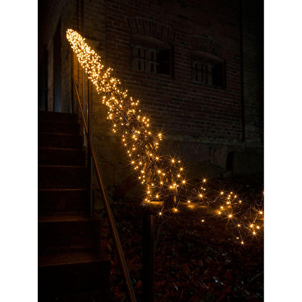 9m Micro LED cluster fairy lights with 8 functions, 960 amber diodes IP44 on a stair railing in the dark.