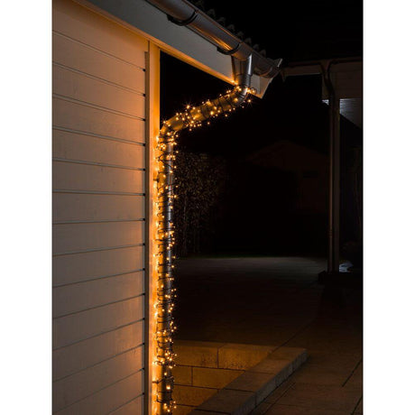 40m Micro LED Lichterkette 1000 bernsteinfarbene Dioden IP44 dekoriert ein Haus in der Nacht.