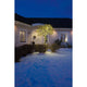 18m Micro LED Lichterkette 600 Warmweiße Dioden IP44 erleuchtet Baum vor Haus im Schnee bei Nacht.