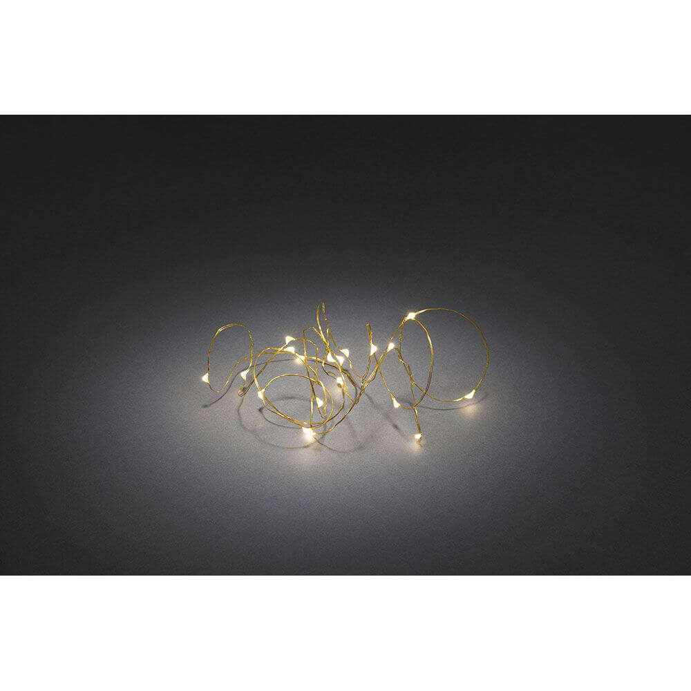 2,4m Micro LED Lichterkette Timer 20 Warmweiße Dioden batteriebetrieben, warmes Licht auf einer dunklen Fläche.