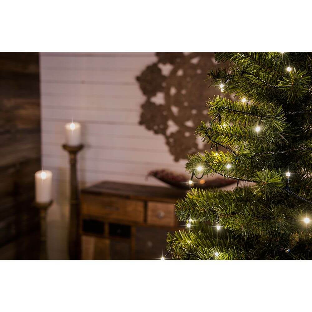 Stimmungsvoll beleuchteter Weihnachtsbaum mit 12m Micro LED Lichterkette gefrostet 10 Warmweiße Dioden im Hintergrund.