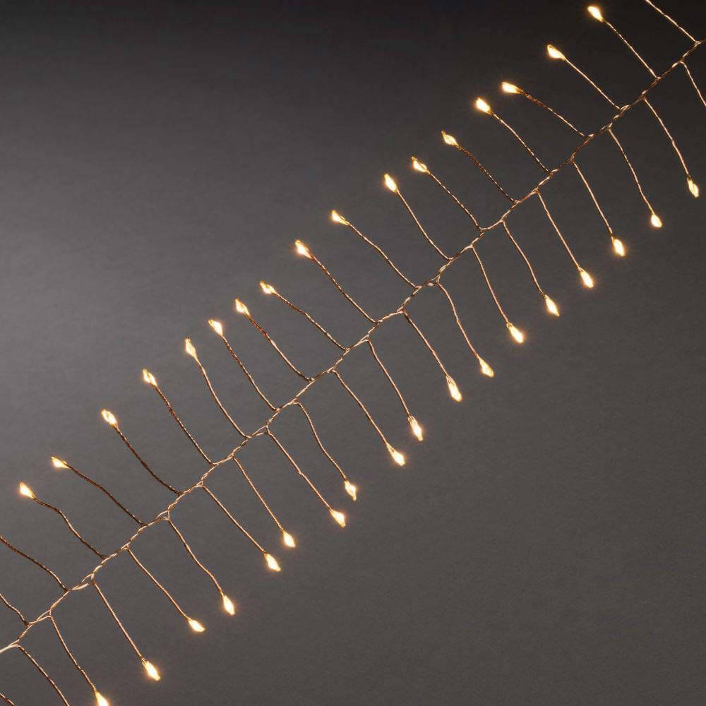 1,5m Micro LED Lichterkette Firecracker mit Timer 60 bernsteinfarbene Dioden batteriebetrieben auf einem schwarzen Hintergrund.