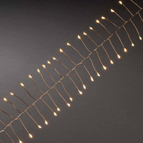 1,5m Micro LED Lichterkette Firecracker mit Timer 60 bernsteinfarbene Dioden batteriebetrieben auf einem schwarzen Hintergrund.