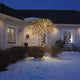 16m Micro LED Lichterkette mit Aufroller 40 bernsteinfarbene Dioden IP44 beleuchtet einen Baum im Schnee vor einem Haus.