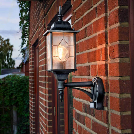 Lampada da parete esterna Milano con sensore nera, argento, aspetto cristallo di piombo installata su muro di mattoni