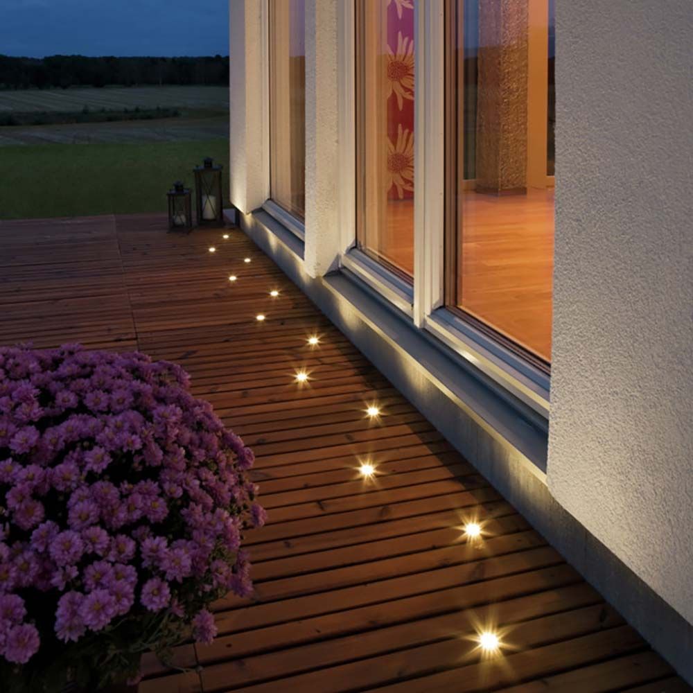 Mini Bodeneinbaustrahler 3er-Set auf Holzterrasse, minimalistische Beleuchtung mit G4 Fassung zur Außenanwendung.