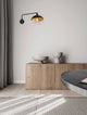 Mirba Wandleuchte Schwarz, Gold über einem modernen Sideboard in einem stilvollen Raum.