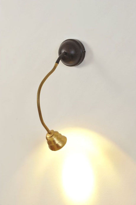 Wandleuchte Snail Two mit schwarzer Wandhalterung, biegsamem Flexarm in Messing und rundem Glasschirm Ø 10cm, eingeschaltet an Wand montiert