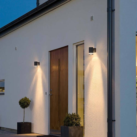 Applique extérieure Modena noire avec réflecteur sur mur de maison, design élégant et éclairage optimal.