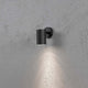 Modena Außen-Wandleuchte Schwarz, klares Glas, Reflektor an einer Wand mit sanftem Lichtschein.