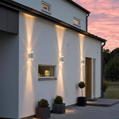 Modena Außen-Wandleuchte mit doppeltem Lichtkegel Weiß, klares Acrylglas, Reflektor an einer modernen Hauswand.