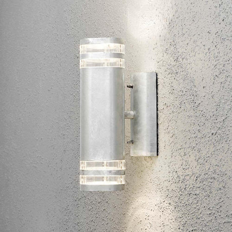 Lampada da parete esterna Modena con fascio di luce in acciaio galvanizzato rappresentata su una parete.