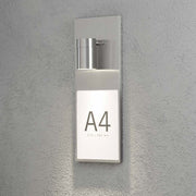 Modena Number DIN A4 lampada per numero civico in acciaio inox montata su un muro, design moderno.