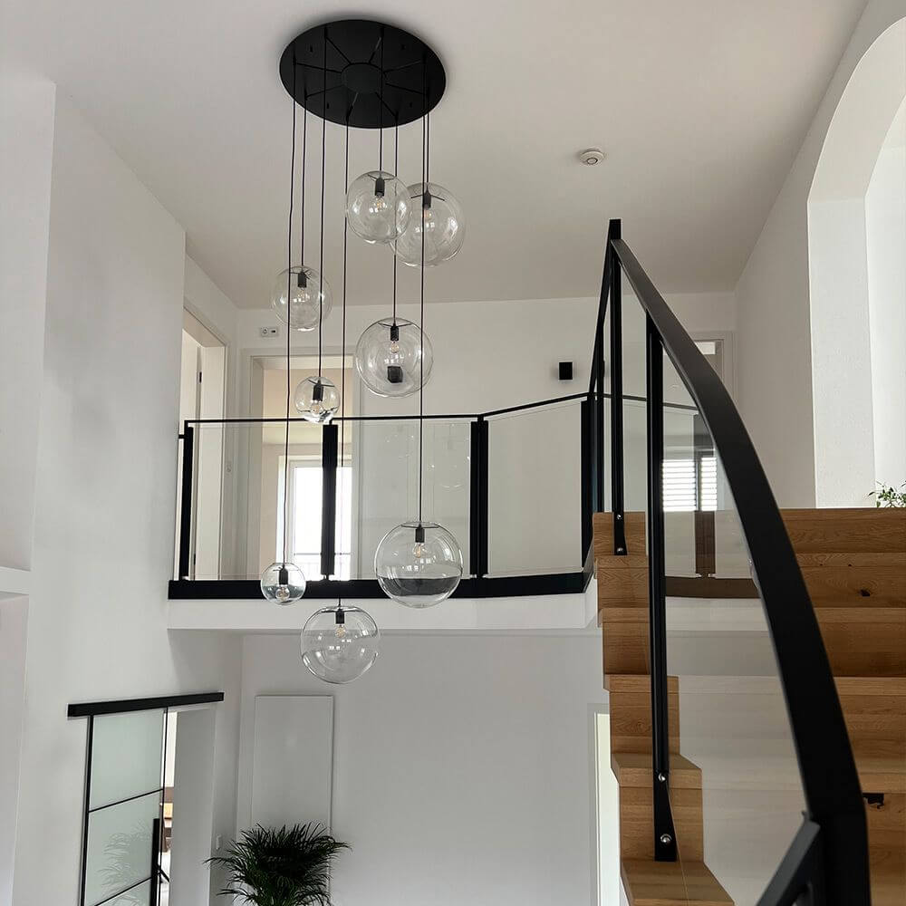 s.luce Modular Baldachin mit transparenten Glaskugeln über einer modernen Treppe in einem hellen Raum