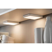 Möbel Aufbauleuchte LED Vane eckig 2er-Set LED-Modul 2x6, 7W unter einem Regal, strahlendes Warmweiß.