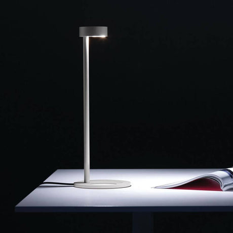 Iven LED Schreibtischlampe asymmetrisch 3-Stufen Schwarz auf einem Tisch mit einem Magazin.