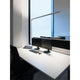 Moderne Büroarbeitsplatz mit Lens Stehlampe, zwei Monitoren und ergonomischem Stuhl.