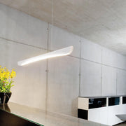 Stretto LED suspension 135 cm 1690 lumens blanc dans un intérieur moderne avec des fleurs.