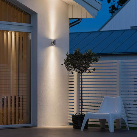 Monza LED outdoor wall light with double light beam on an exterior house wall.