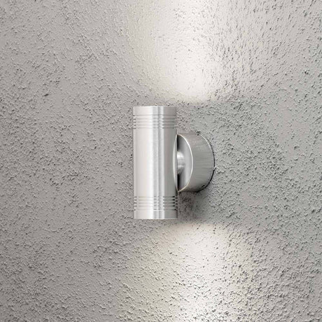 Monza LED Außen-Wandleuchte mit doppeltem Lichtkegel an grauer Wand montiert.