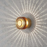 Bronzefarbene Monza LED Außen-Wandleuchte mit dekorativem Lichteffekt auf Betonwand.