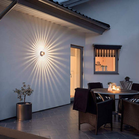 Monza LED effect outdoor wall light in copper color casts decorative light patterns onto an outdoor wall.