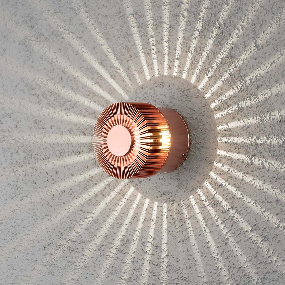 Monza LED Wandleuchte in kupferfarben, dekoratives Lichtmuster an der Wand, ideal für Außenbereiche.